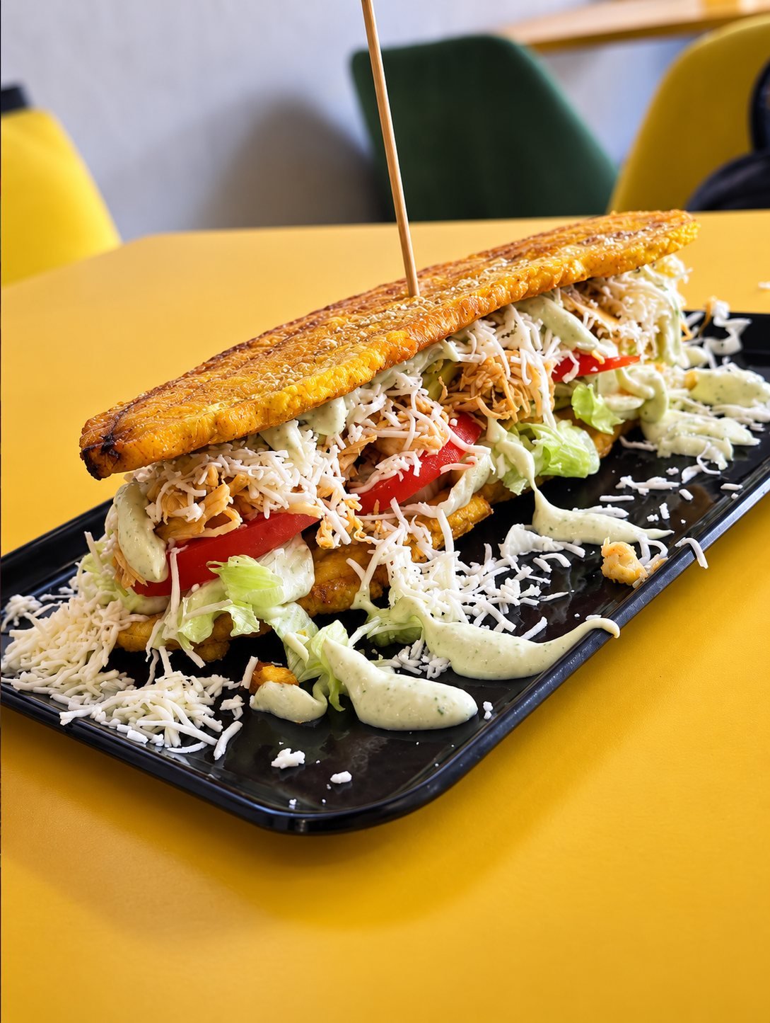 Patacón relleno de pollo mechado, queso y salsa verde